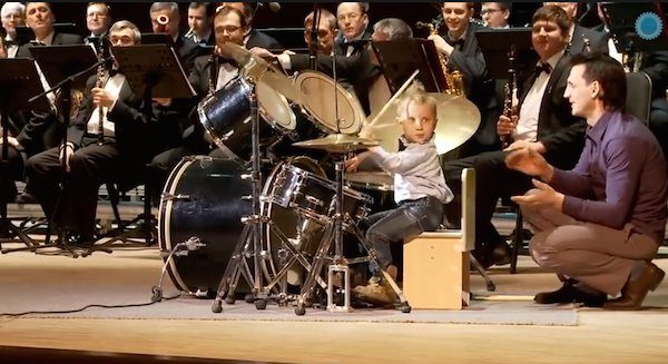 boy drums with orchestra