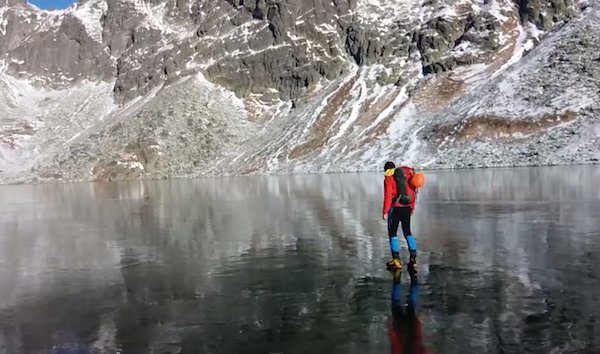 hikers walk on clear ice lake