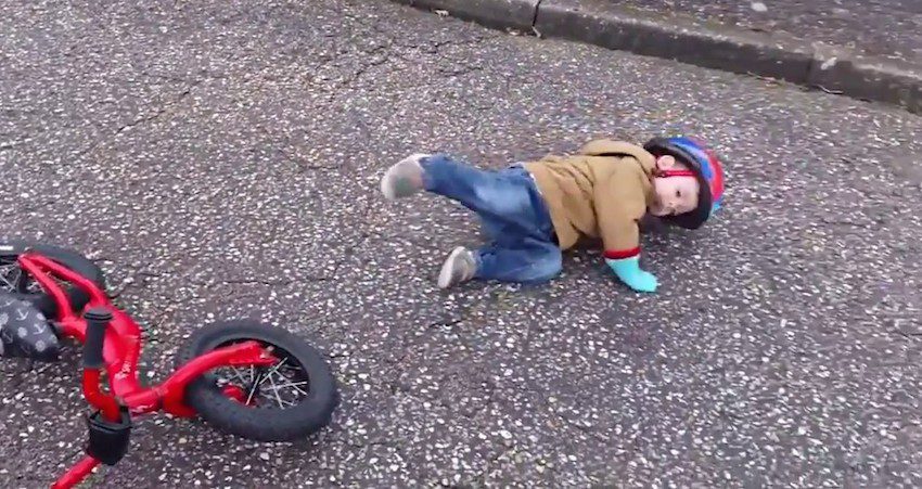 Little Boy Hilariously Fakes 'Bike Accident' To Get Attention From His Dad